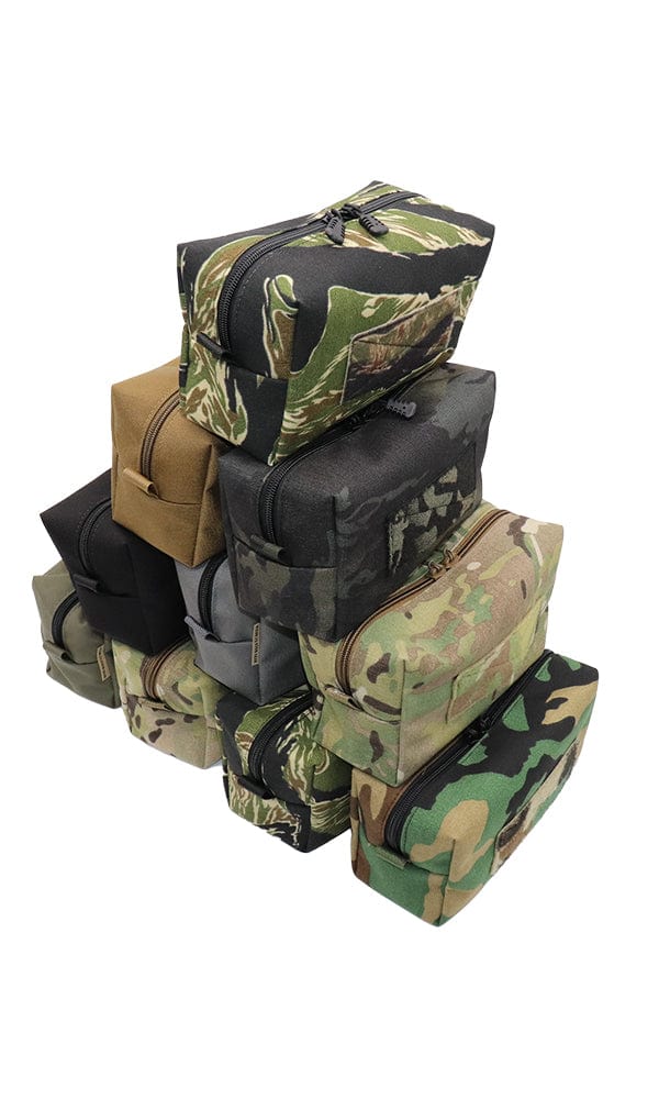 Variety of Tactical Dopp Kits stacked, displaying multiple colors and patterns for versatile use.