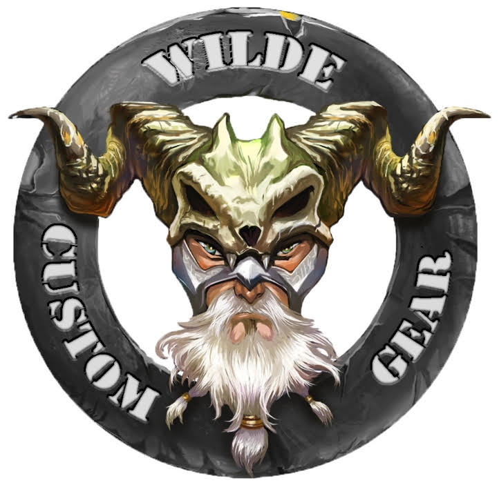 A circular logo featuring a mythical warrior with horns, a white beard, and intense eyes, surrounded by the text 'Wilde Custom Gear,' symbolizing strength and craftsmanship.